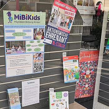 verschiedene Bücher und bunte Plakate in einem Schaufenster