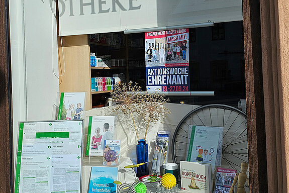 Schaufenster mit Büchern, Igelbällen, einer Holzfigur und einem kleinen Drahtfahrrad