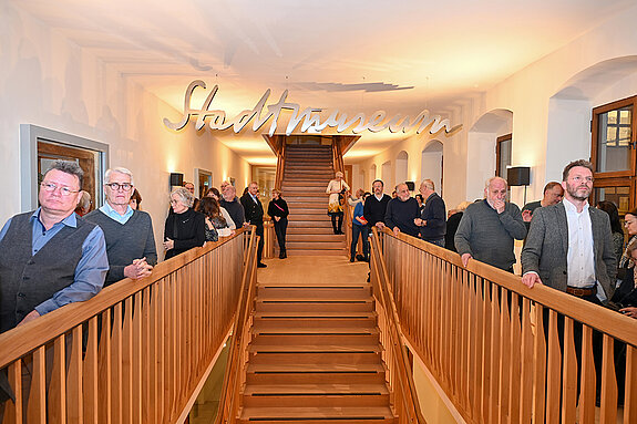 Aufmerksam verfolgten im Treppenhaus des Asamgebäudes die Besucherinnen und Besucher die einführenden Worte zur Studioausstellung. (Foto. Stadt Freising)