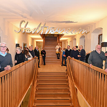 Aufmerksam verfolgten im Treppenhaus des Asamgebäudes die Besucherinnen und Besucher die einführenden Worte zur Studioausstellung. (Foto. Stadt Freising)