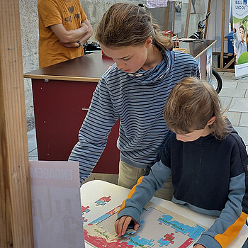 zwei Kinder setzen das „Eine-faire-Welt-Puzzle“ zusammen