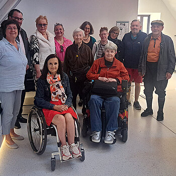 Gruppenbild mit 1. Bürgermeister Resch, 3. Bgm. Marion Huber-Schallner, Sozialreferentin Dr. Reitsam und der Gruppe. Foto: Andrea Gurr Gruppenbild mit 2 Rollstuhlfahrerinnen in einem Raum mit Dachschräge