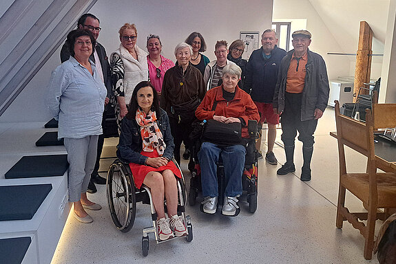Gruppenbild mit 1. Bürgermeister Resch, 3. Bgm. Marion Huber-Schallner, Sozialreferentin Dr. Reitsam und der Gruppe. Foto: Andrea Gurr Gruppenbild mit 2 Rollstuhlfahrerinnen in einem Raum mit Dachschräge