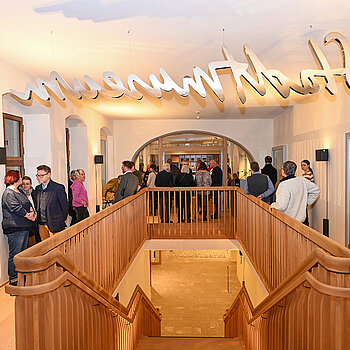 Als Ort der Ausstellungseröffnung war der große Raum des Treppenhauses gewählt worden, der mit seinen bodentiefen Verglasungen Einblicke in die Museumsräume bietet. (Foto: Stadt Freising) 