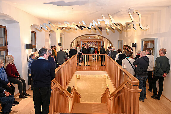 Aufmerksam verfolgten im Treppenhaus des Asamgebäudes die Besucherinnen und Besucher die einführenden Worte zur Studioausstellung. (Foto. Stadt Freising)